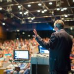 Public speaker giving talk at Business Event.