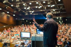 Public speaker giving talk at Business Event.